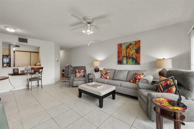 tiled living room featuring a textured ceiling and ceiling fan