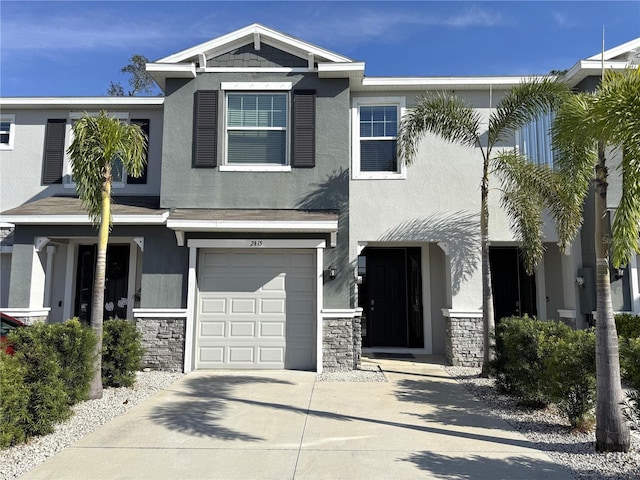 view of front of house featuring stone siding, concrete driveway, an attached garage, and stucco siding