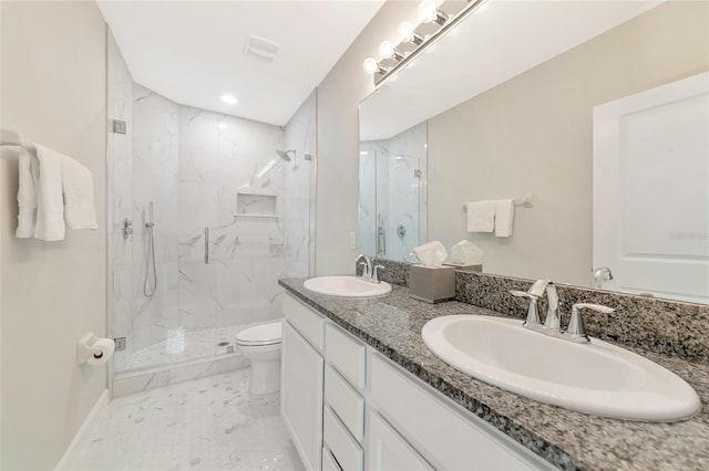 bathroom featuring vanity, a shower with shower door, and toilet