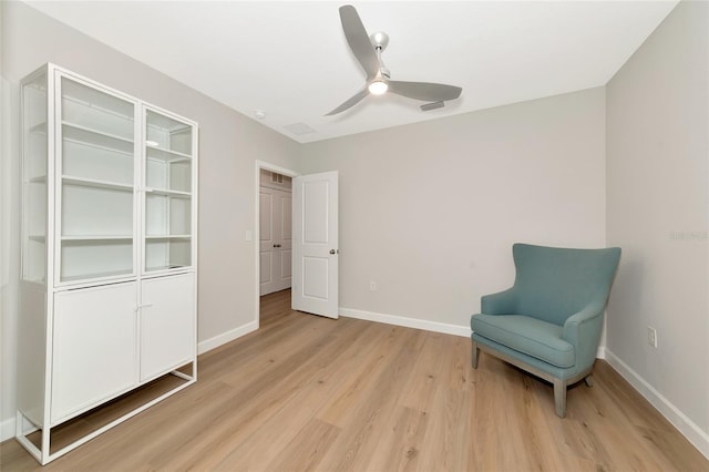 sitting room with ceiling fan and light hardwood / wood-style flooring