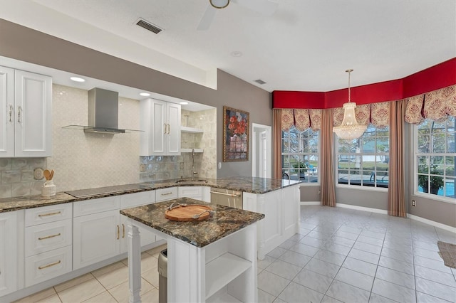 kitchen featuring white cabinetry, dark stone counters, a center island, black electric cooktop, and wall chimney exhaust hood