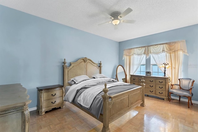 bedroom featuring ceiling fan, a textured ceiling, and light parquet flooring