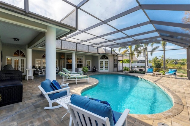 view of swimming pool featuring a patio area, glass enclosure, and french doors