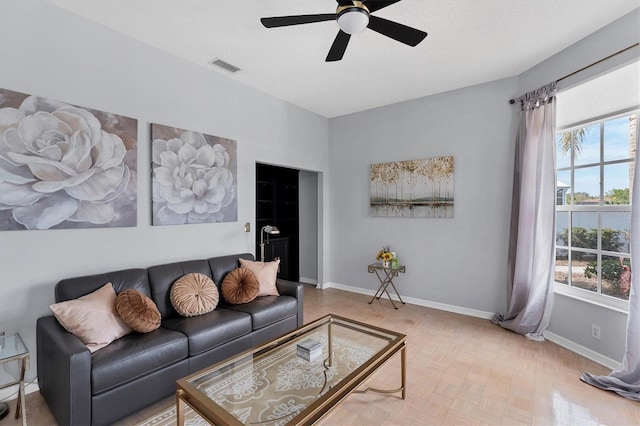 living room featuring parquet floors, a textured ceiling, and ceiling fan