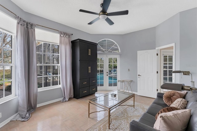 living room featuring ceiling fan, a textured ceiling, and french doors