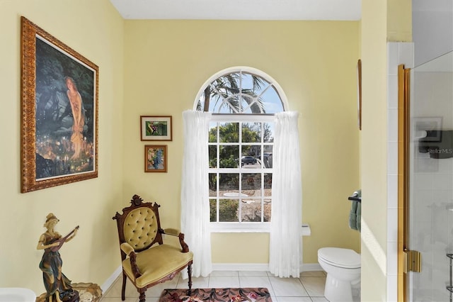 bathroom with tile patterned floors, toilet, and an enclosed shower