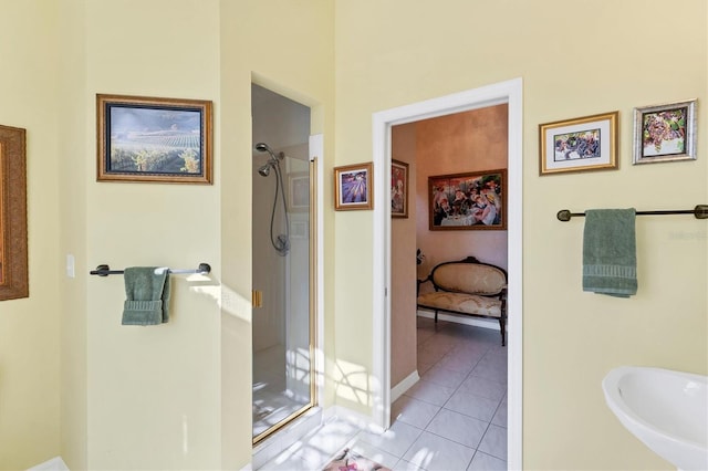 bathroom featuring sink, a shower with shower door, and tile patterned flooring