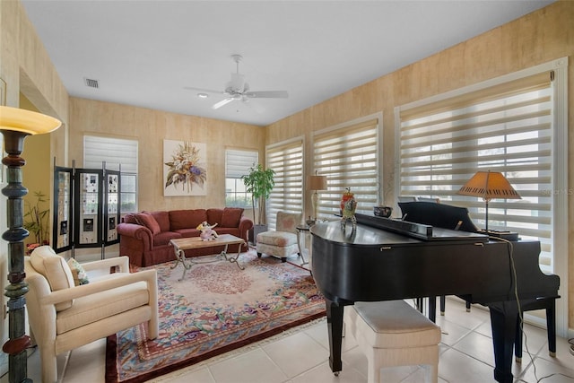 living area with ceiling fan and light tile patterned flooring