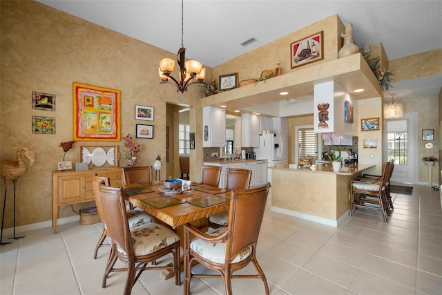 tiled dining space with a chandelier