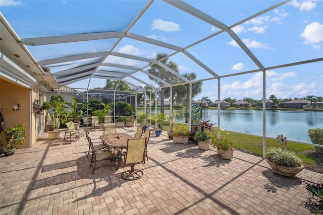 view of patio with a lanai and a water view