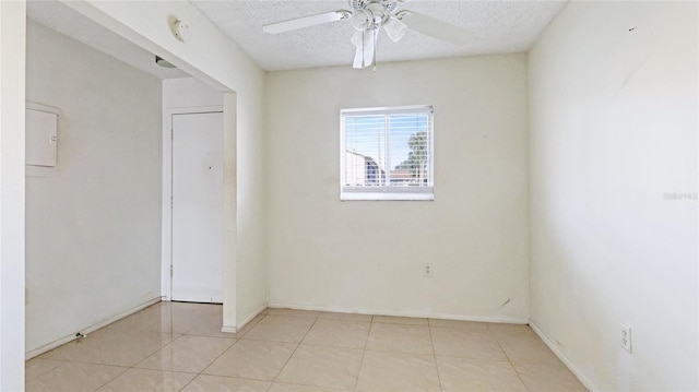 unfurnished room featuring light tile patterned flooring, ceiling fan, and a textured ceiling