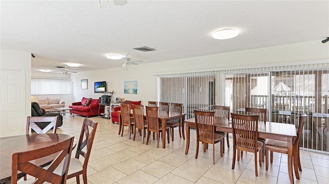 tiled dining space with ceiling fan