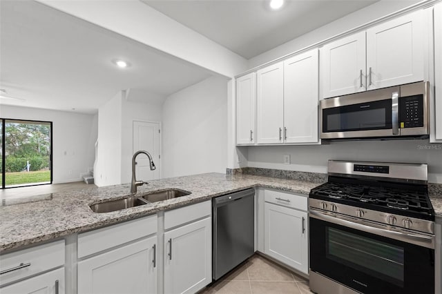 kitchen featuring appliances with stainless steel finishes, light stone countertops, sink, and white cabinets