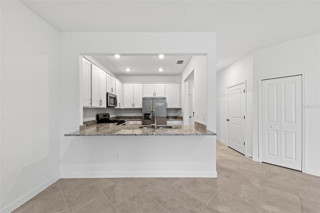 kitchen with sink, kitchen peninsula, stainless steel appliances, light stone countertops, and white cabinets