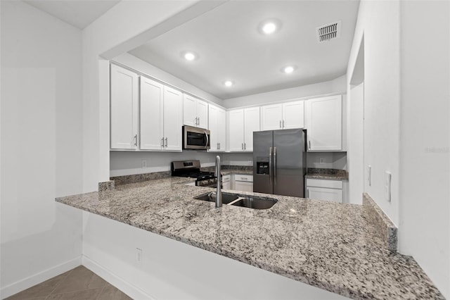 kitchen featuring white cabinetry, appliances with stainless steel finishes, sink, and kitchen peninsula