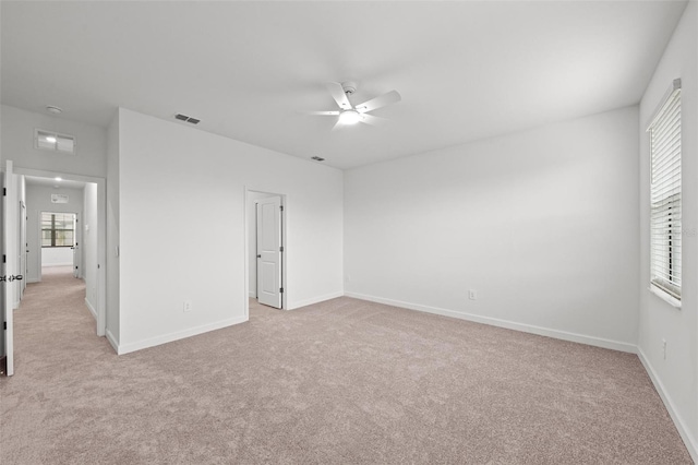 spare room featuring light colored carpet and ceiling fan