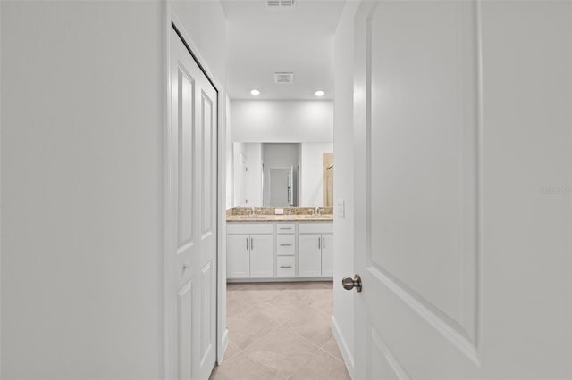 corridor with light tile patterned flooring and sink