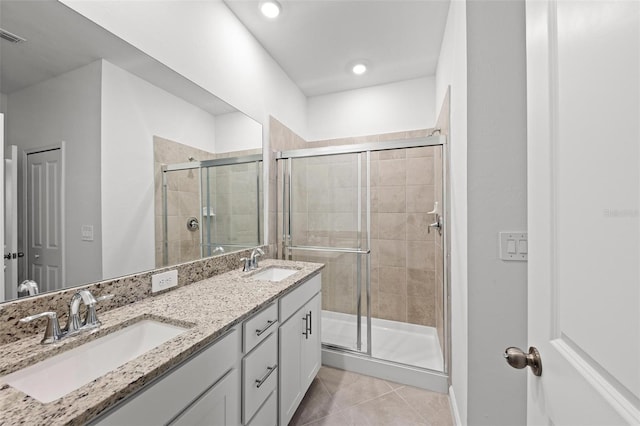 bathroom with tile patterned floors, a shower with door, and vanity