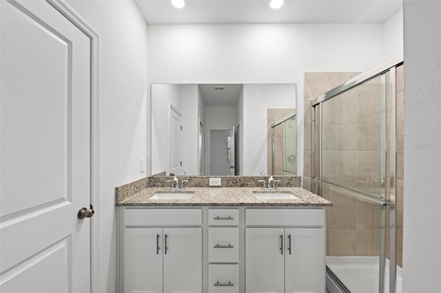 bathroom with vanity and a shower with shower door