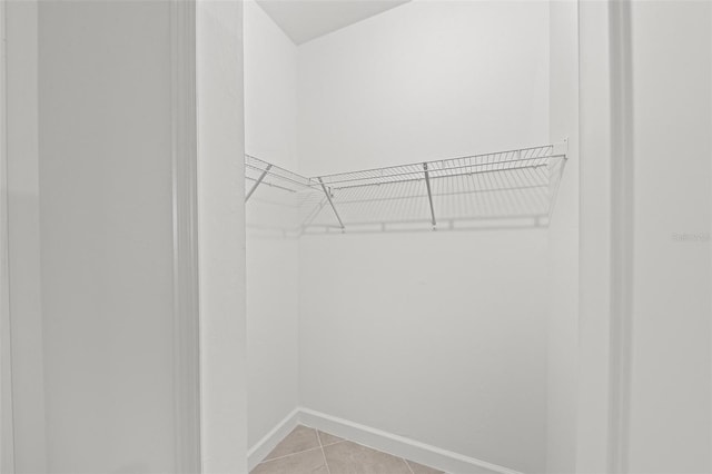 walk in closet with light tile patterned floors