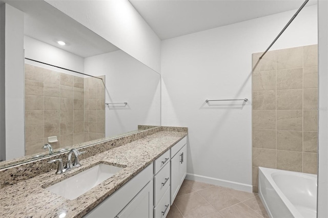 bathroom featuring tiled shower / bath, vanity, and tile patterned flooring