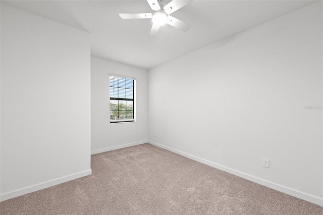 empty room featuring ceiling fan and light carpet