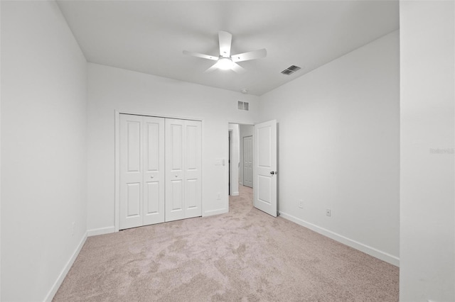 unfurnished bedroom featuring light carpet, a closet, and ceiling fan