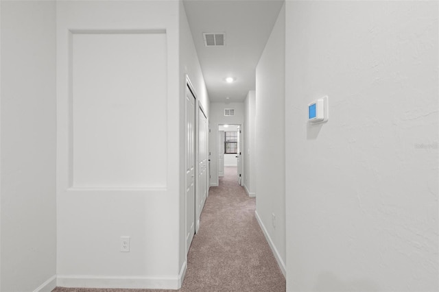 corridor featuring light colored carpet