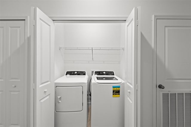 clothes washing area with separate washer and dryer