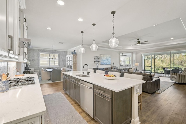 kitchen featuring dishwasher, white cabinetry, sink, an island with sink, and hanging light fixtures