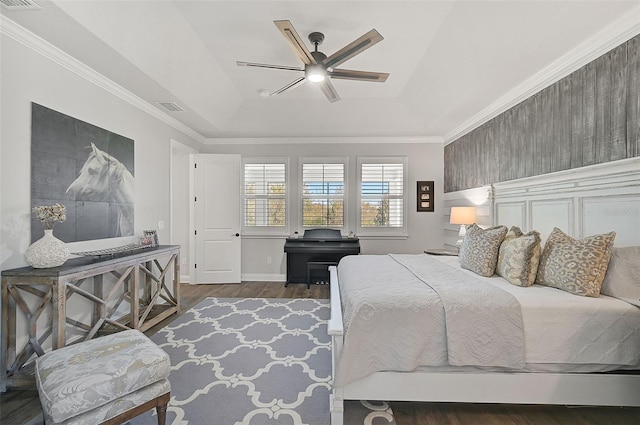 bedroom featuring dark hardwood / wood-style flooring, a tray ceiling, ornamental molding, and ceiling fan