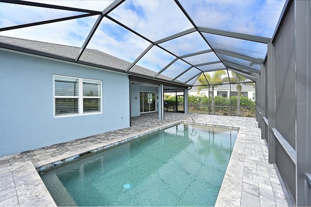 view of swimming pool with glass enclosure and a patio area