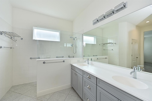 bathroom featuring a tile shower, vanity, and tile patterned floors