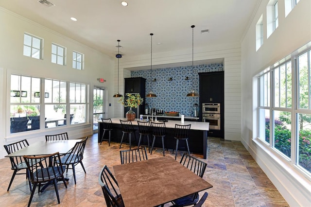 dining room with crown molding and a towering ceiling