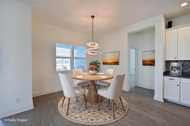 dining area featuring dark wood-type flooring and a notable chandelier