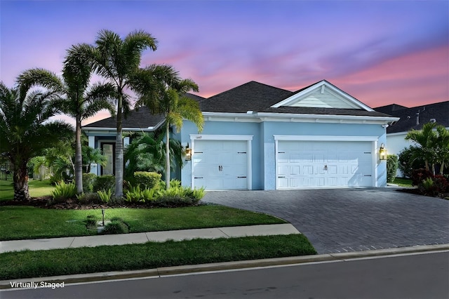 view of front of property with a garage and a yard