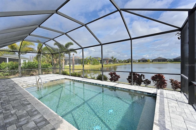 view of swimming pool with a water view, glass enclosure, and a patio area