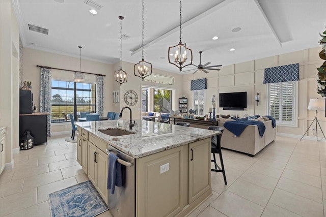 kitchen featuring sink, light stone counters, a center island with sink, stainless steel dishwasher, and pendant lighting