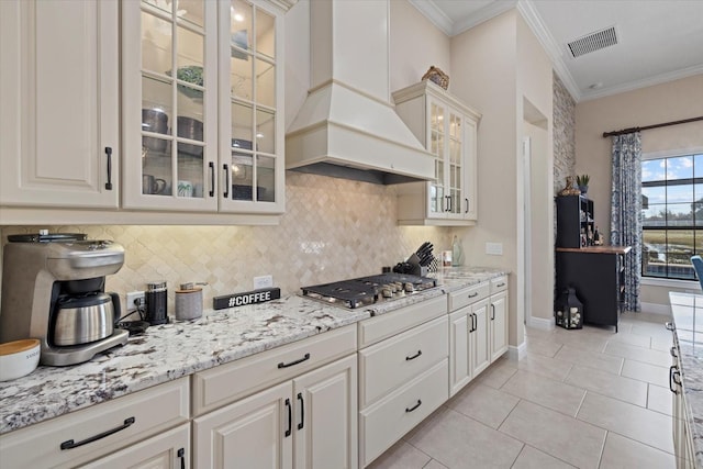 kitchen featuring white cabinetry, stainless steel gas cooktop, and custom range hood