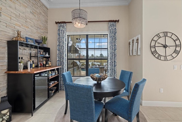 tiled dining space with crown molding, bar, beverage cooler, and an inviting chandelier