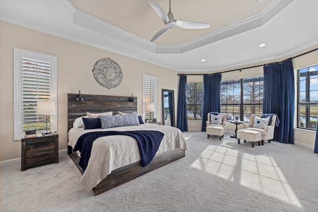 carpeted bedroom featuring crown molding, a tray ceiling, and ceiling fan