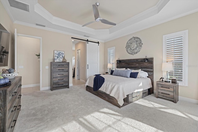 carpeted bedroom featuring ceiling fan, ornamental molding, a barn door, and a raised ceiling