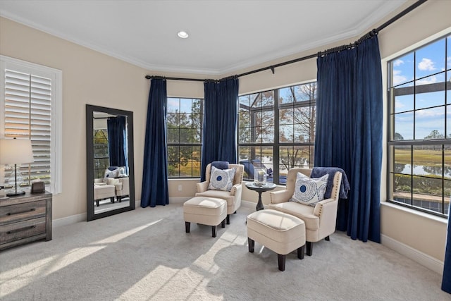 sitting room featuring crown molding, a healthy amount of sunlight, and light colored carpet