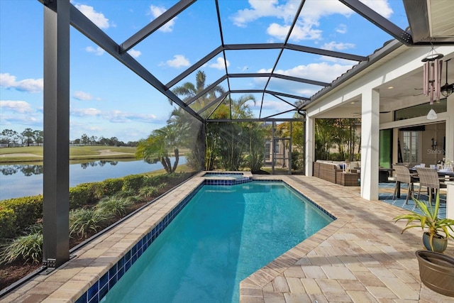 view of swimming pool featuring a patio, outdoor lounge area, an in ground hot tub, a lanai, and a water view