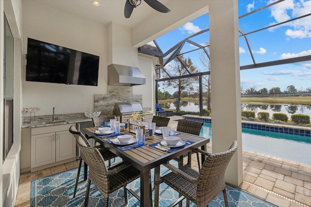 view of patio / terrace with a water view, area for grilling, sink, and glass enclosure