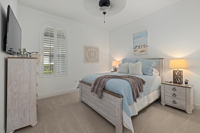 bedroom featuring ceiling fan, baseboards, and light colored carpet