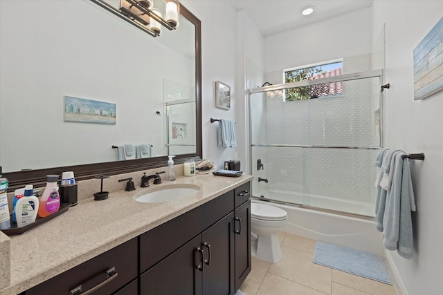 full bathroom with bath / shower combo with glass door, vanity, toilet, and tile patterned floors