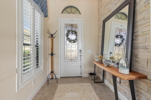 entryway with light tile patterned floors and baseboards