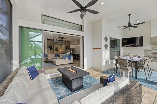 living area featuring a ceiling fan, recessed lighting, and stone tile floors