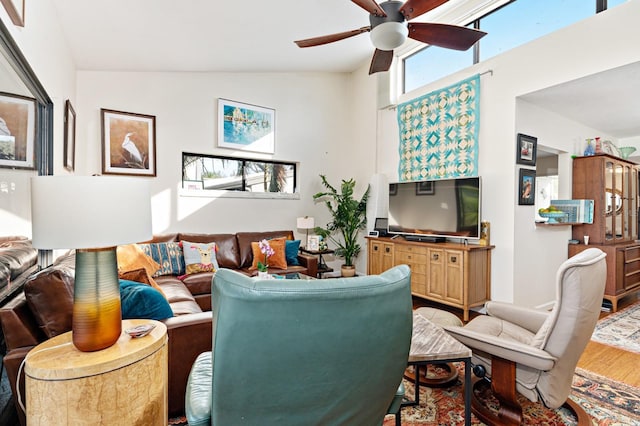 living room featuring wood-type flooring, high vaulted ceiling, and ceiling fan